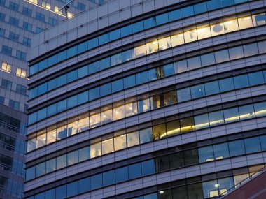 Aydınlatılmış modern ofis binası alacakaranlıkta parlayan pencereler ve parlak mimari tasarım ile