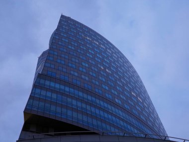 Şehir Mimarisinde Akşam Mavi Gökyüzünü Yansıtan Modern Eğri Cam Bina Cephesi