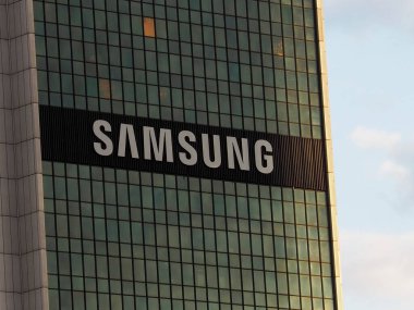 Samsung Kurumsal Logosu Modern Cam Gökdelen Cephesi Mavi Gökyüzü ve Güneş Işığı Yansıması