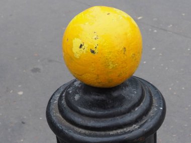 Parlak Sarı Top Koyu Metal Bollard Konumu Güçlü Görsel Karşıtlık Oluşturuyor