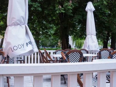 Beyaz Şemsiyeli Konforlu Açık Hava Restoran Bahçesi ve Yeşil Ağaçların Altında Ahşap Mobilya