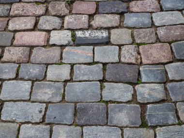 Yıpranmış taş kaldırım taşının doğal dokuyu ve yaşlanma şekillerini gösteren yakın plan detayları.