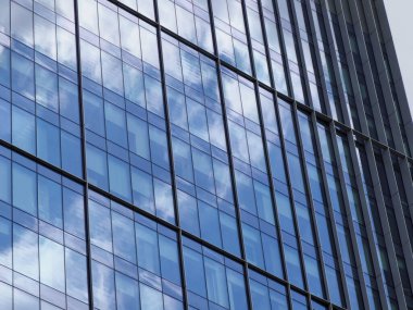 Mavi yansıtıcı pencere ve metal çerçeve geometrik desenli modern cam ofis cephesi