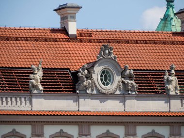 Süslü heykelleri ve mavi gökyüzüne karşı kırmızı kiremit çatılı Barok saray cephesi