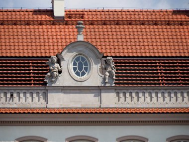 Dekoratif saat ve heykel unsurları içeren dekoratif barok bina cephesi