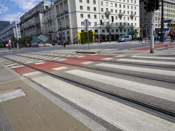 Tramvay, modern şehir ortamında geometrik sokak modelleri ve şehir mimarisi ile kesişen yolları izler.