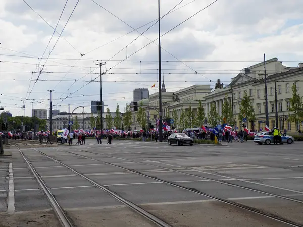 Politik gösteriler sırasında dağınık katılımcılarla Varşova caddelerinin tramvay raylarıyla kesiştiği geniş bir manzara