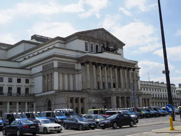 Tarihi Varşova mimarisinin etrafında modern şehir yaşamını gösteren park halindeki arabalarla Neoklasik Hükümet Binası