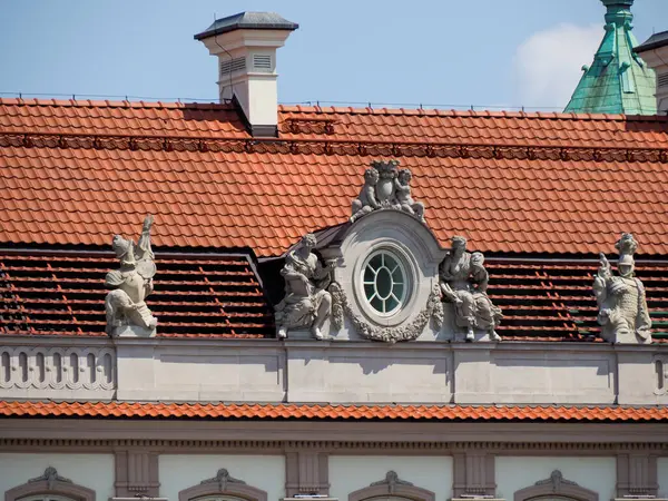 Süslü heykelleri ve mavi gökyüzüne karşı kırmızı kiremit çatılı Barok saray cephesi