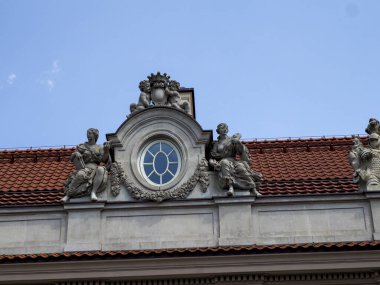 Bulutlu gökyüzüne karşı Avrupa 'nın mimari işçiliğini gözler önüne seren tarihi yapı cephesi üzerindeki barok saat ve heykel detayları
