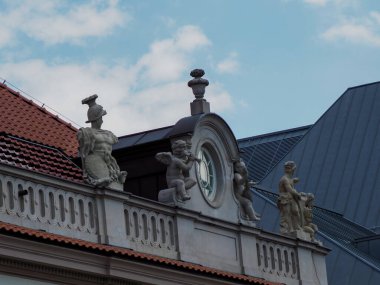 Tarihi Avrupa kentsel ortamında mimari simetri yaratan süslü saat ve heykel süslemeleri ile klasik bina cephesi