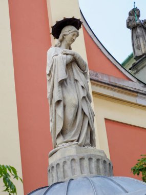 Haçlı taş dini heykel mercan pembe kilise duvarına çarpıyor.