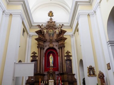 Süslü altın sunağı ve beyaz kemerlerin altında kırmızı dini ikonografisi olan Barok kilise tarafı şapeli.