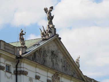 Dekoratif heykel figürleri ve bulutlu gökyüzüne karşı dekoratif mimari detaylarla neoklasik çatı