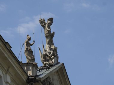 Barok taş melekler ve heykeller mavi gökyüzüne karşı tarihi yapılar inşa ediyorlar.