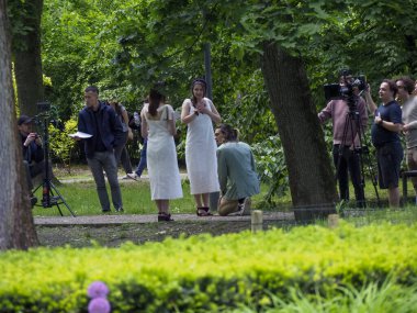 Gelin ve misafirlerin dışarıda toplandığı yemyeşil parkta düğün kutlaması.