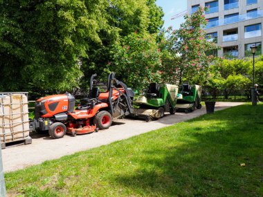 Kentsel park alanındaki peyzaj projesinde çalışan turuncu inşaat ekipmanları ve makineler