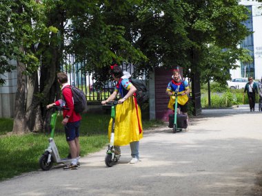 Renkli ortaçağ kostümlü sokak göstericileri şehir parkında geleneksel halk danslarıyla turistleri eğlendiriyorlar.