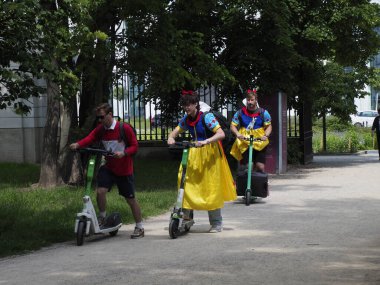 Canlı geleneksel kostümlü halk dansçıları halka açık park ortamında enerjik dans gösterileri sergiliyorlar.