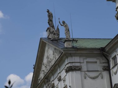 Süslü barok kilise kulesi heykel detaylarıyla görkemli bir şekilde gökyüzüne karşı yükseliyor.