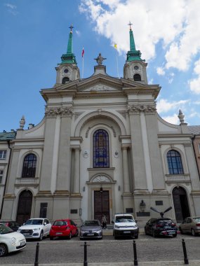 Varşova 'da dramatik mavi gökyüzünün altında ikiz çan kuleleriyle barok kilise cephesi