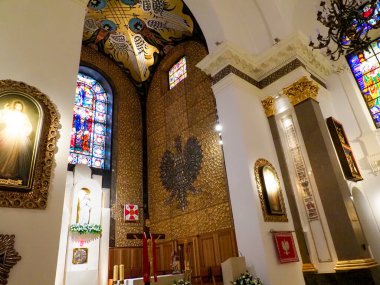 Sivri kemerli gotik kilise içi renkli vitray pencereler ve geleneksel dini mimari öğeler sergiliyor.