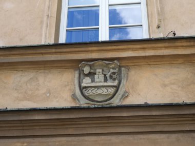 Geleneksel Varşova binası cephesinde taç süslemeli tarihi taş armalar.