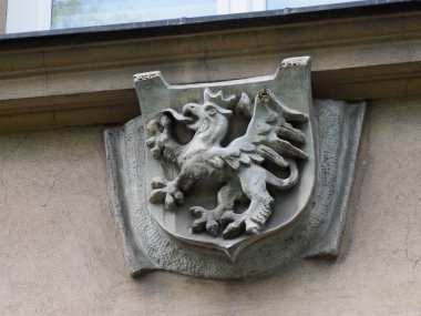 Tarihi bina cephesine oyulmuş kraliyet aslanlı ortaçağ taş arması.