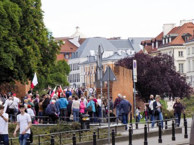 Halk mitingine katılan bayraklı insanlar veya geleneksel Avrupa mimarisi ile tarihi şehir merkezinde yürüyüş
