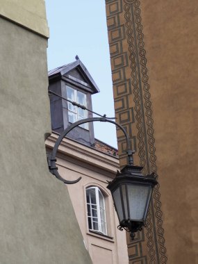 Tarihi Avrupa binasının köşesinde klasik sokak lambası ve eski kasabadaki sıcak cephe renkleriyle geleneksel mimari sergileniyor.