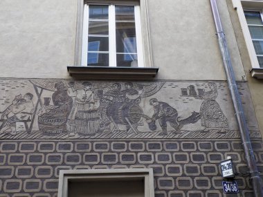 Ortaçağ Avrupa mimari unsurlarını sergileyen dekoratif yardım heykelleri ve küçük pencereli tarihi taş bina