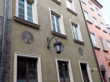 Pastel renkli tarihi binalar ve geleneksel pencerelerle büyüleyici Avrupa caddesi köşesi pitoresk şehir manzarası yaratıyor