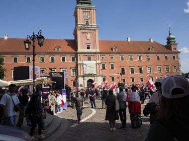 Güneşli bir günde Varşova 'daki tarihi Royal Castle Meydanı' nda kalabalık toplanıyor.
