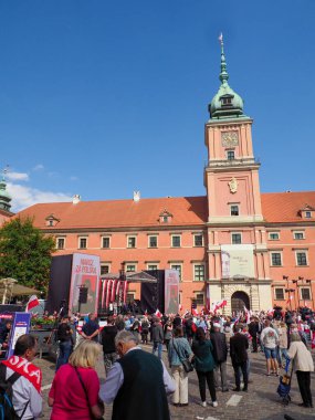 Varşova Kraliyet Kalesi meydanı ziyaretçilerle ve güneşli bir günde renkli festival dekorasyonlarıyla dolu.