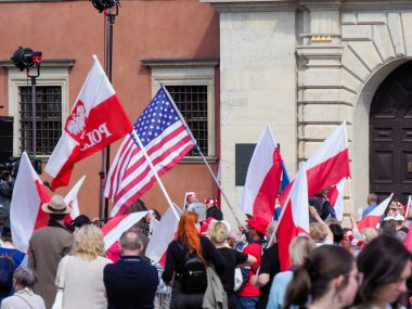 Vatanseverlik gösterisi sırasında tarihi şehir meydanında toplanan Polonya ve Amerikan bayrakları sallanıyor