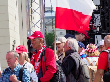 Yaşlı Polonyalı vatanseverler, şehir merkezinde düzenlenen vatanseverlik mitinginde kırmızı ve beyaz bayraklar sallıyorlar.