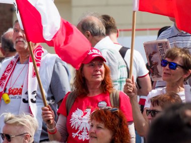 Polonyalı vatanseverler açık hava halk gösterileri sırasında ulusal bayraklar sergiliyorlar.