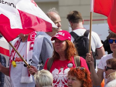 Şehir merkezindeki vatansever kutlamalar sırasında coşkulu Polonya vatandaşları kırmızı ve beyaz bayraklar sallıyor.