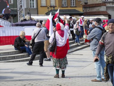 Geleneksel Polonya halk kostümlü yaşlı kadın Bağımsızlık Günü kutlamalarına kırmızı ve beyaz bayraklarla katılıyor