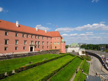 Manikürlü bahçeleri ve parlak yaz güneşinde yürüyen turistleri olan Royal Castle Varşova