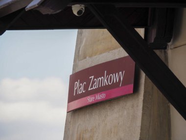 Krakow 'un eski kasabasındaki Castle Meydanı tabelasında geleneksel şehir seyrüsefer ve tarihi bölge işaretleri gösteriliyor.