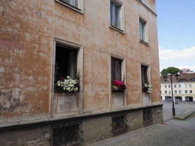 Avrupa sokaklarına bakan pencerelerde dekoratif çiçek kutuları olan büyüleyici mercan renkli bina cephesi