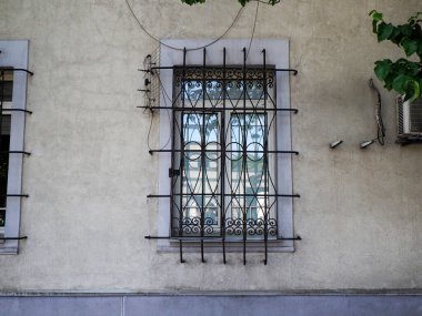 Geleneksel mimari tarzında dekoratif siyah metal parmaklıklı beyaz bina penceresi