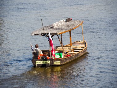 Polonya bayrağıyla geleneksel ahşap turist teknesi ve Varşova yakınlarındaki Vistula sularında nehir turu yapan yolcular.