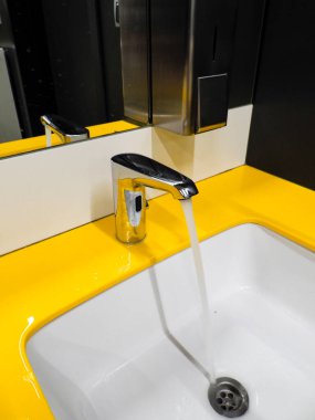 Modern krom musluk. Çağdaş banyo iç tasarımında parlak sarı aksan duvarlı.