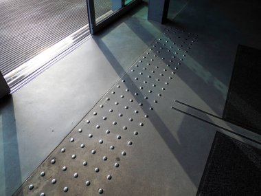 Açısal metalik endüstriyel merdiven ve delinmiş basamaklar geometrik gölge desenleri yaratıyor