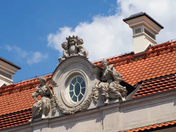 Avrupa şehir mimarisinde mavi gökyüzüne karşı süslü taş heykelleri olan tarihi barok saat kulesi