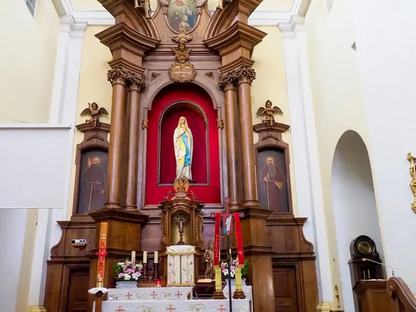 Barok kilisesinin sunağını altın süslemeler ve kutsal atmosfer yaratan kırmızı dini ikon ile süsleyin.