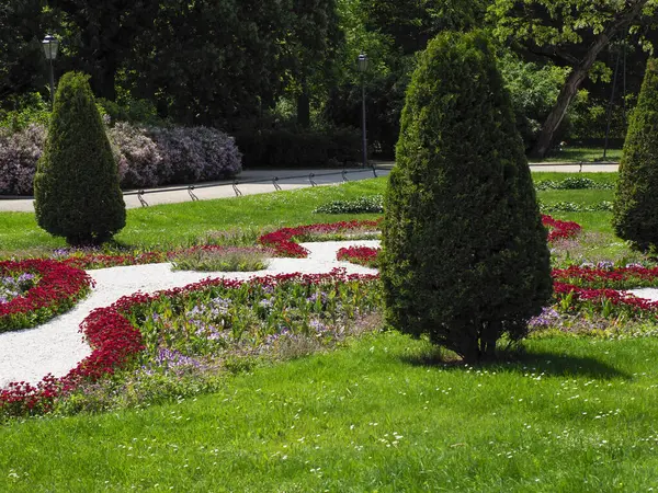 Dekoratif çiçeklerle süslü bahçeler ve mükemmel budanmış ağaç ağaçları.