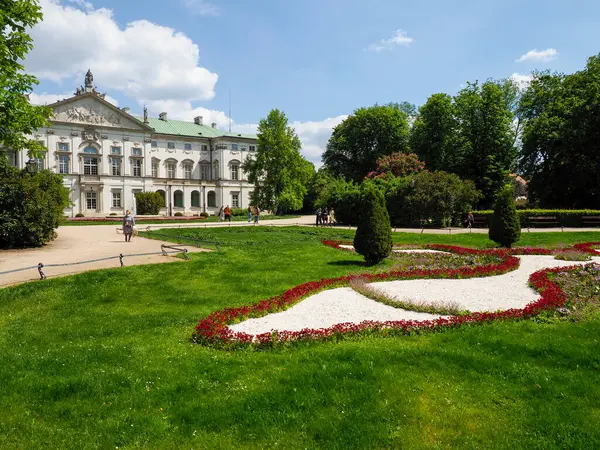 Manikürlü resmi bahçeleri ve yazın geometrik çiçek tarhları olan zarif bir barok sarayı.